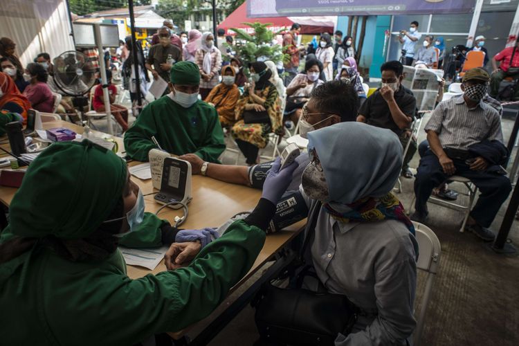 Tenaga kesehatan melakukan pemeriksaan kesehatan kepada warga calon penerima vaksin Covid-19 dosis ketiga saat vaksinasi booster di Puskesmas Kecamatan Kramat Jati, Jakarta Timur, Jakarta, Rabu (12/1/2022). Pemerintah memulai program vaksinasi lanjutan (booster) Covid-19 secara gratis kepada masyarakat umum yang berusia 18 tahun ke atas dengan kelompok prioritas penerima vaksin adalah orang lanjut usia (lansia) dan penderita immunokompromais.