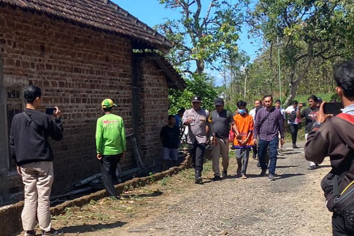 MENUJU LOKASI KEJADIAN—Tersangka Jeki (21) di kawal polisi menuju lokasi pembunuhan di Dusun Jatisari, Desa Semanding, Kecamatan Jenangan, Kabupaten Ponorogo, Jawa Timur. Tersangka memperagakan berbagai adegan saat membunuh Sumiran (57) di lokasi kejadian. 