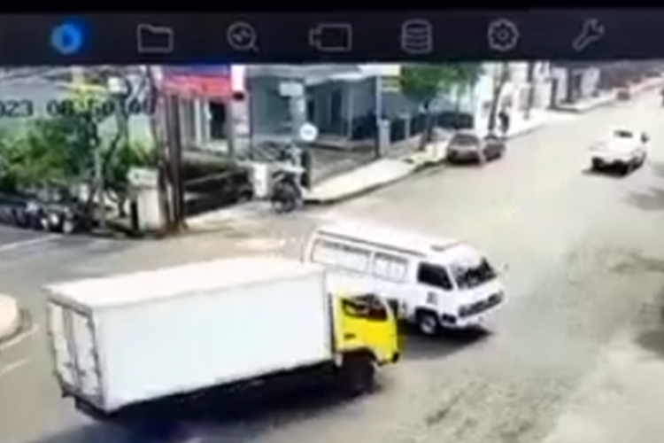 Tangkapan layar video yang memperlihatkan mobil ambulans terbalik usai tertabrak truk boks.