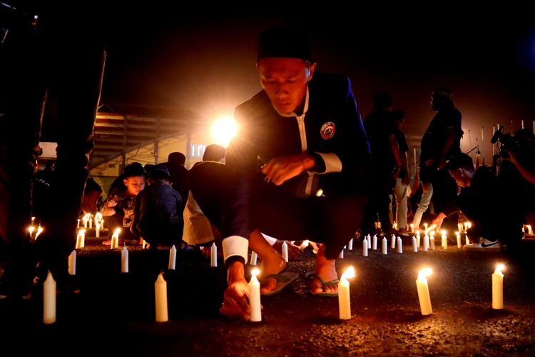 Pemain Arema FC Dendi Santoso menyalakan lilin sebelum doa bersama ribuan Aremania untuk memperingati 40 hari Tragedi Kanjuruhan yang dilaksanakan di parkiran Stadion Kanjuruhan Kepanjen, Kabupaten Malang, Rabu (9/11/2022) malam.