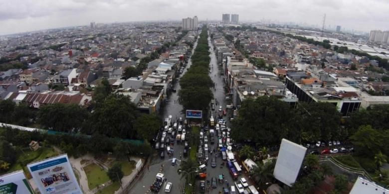 Banjir menggenangi kawasan permukiman dan perekonomian di Kelapa Gading, Jakarta Utara, Selasa (10/2/2015). Jakarta menghadapi masalah penurunan muka tanah. Kondisi itu diperparah oleh semakin minimnya daerah resapan air yang diganti dengan hunian dan gedung-gedung pencakar langit.