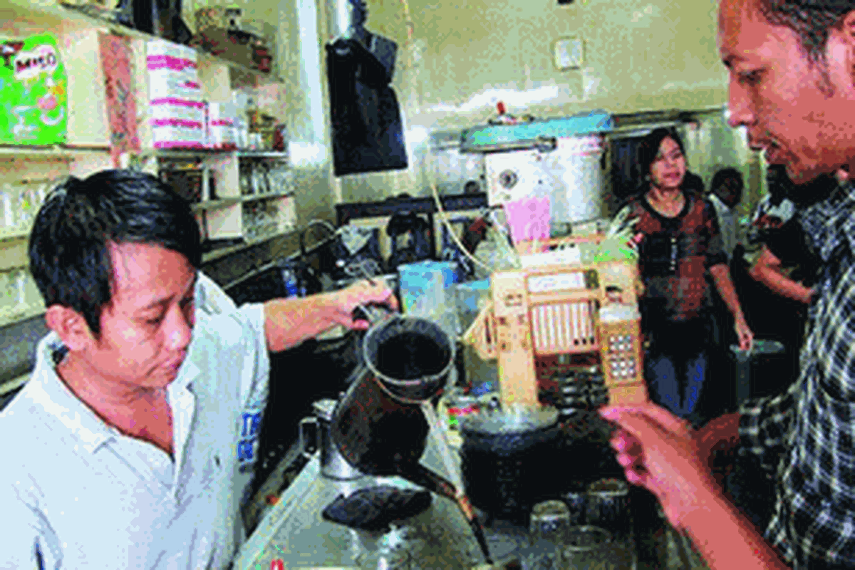 Kasim sang barista peracik kopi sedang melayani pelanggan Warung Suka Hati.  