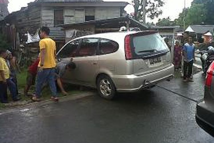 Sejumlah warga di Kabupaten Bone, Sulawesi Selatan berusaha mengevakuasi minibus yang melaju sendiri dan menabrak pagar rumah warga saat pemiliknya asyik makan di restoran. Selasa, (19/11/2013).