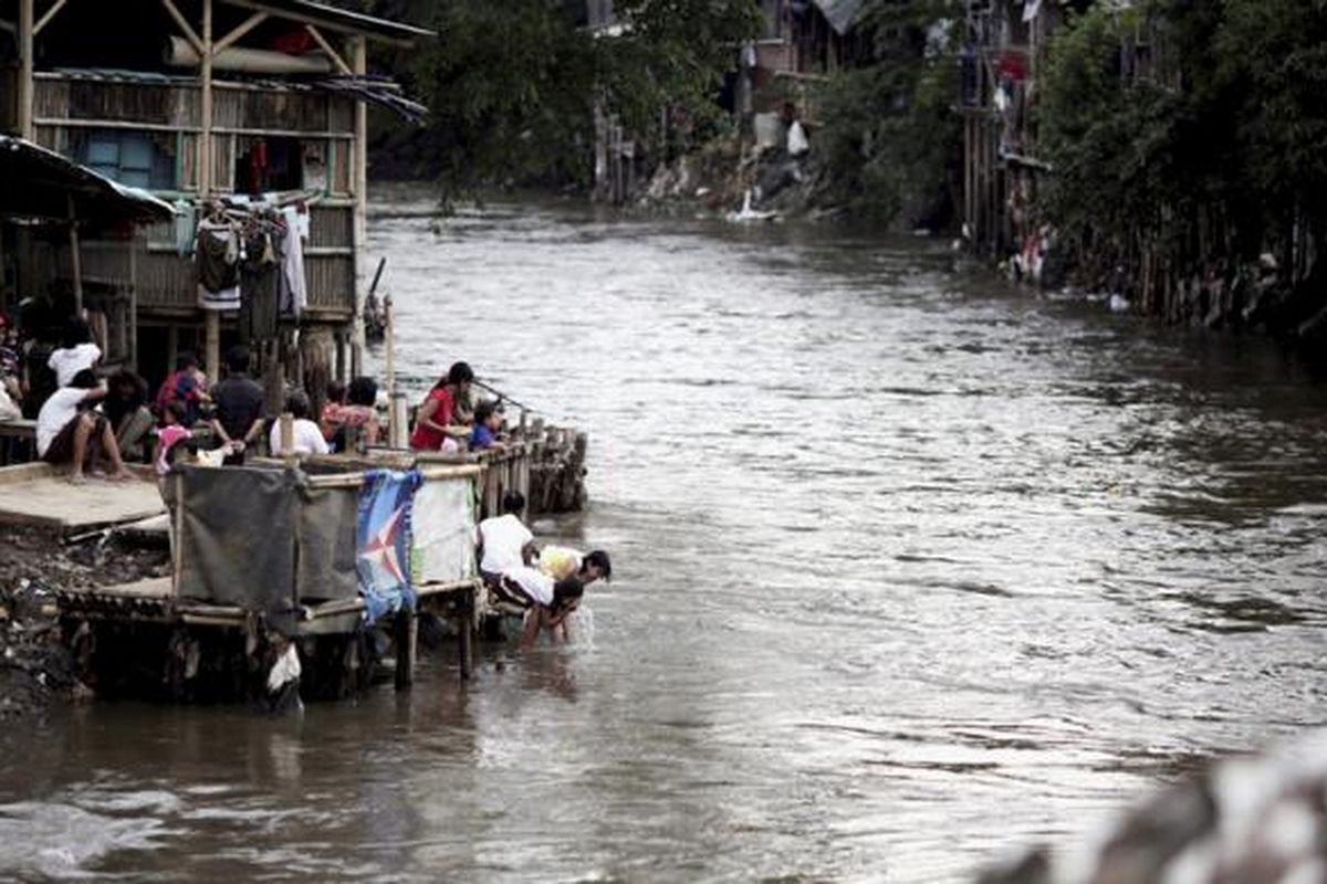 Anak-anak mencuci muka di Kali Ciliwung yang penuh dengan hunian di Kampung Pulo, Kelurahan Kampung Melayu, Kecamatan Jatinegara, Jakarta Timur, Minggu (15/2/2015). Pencemaran sungai di Jakarta sudah jauh di atas ambang batas yang diisyaratkan. bahkan, dari sekitar 807.000 pelanggan air dari dua perusahaan air minum di DKI Jakarta, hampir 300.000 di antaranya tidak terlayani.