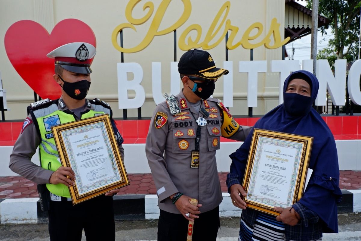 Kapolres Bukittinggi AKBP Dody Prawiranegara didampingi Sri Harlina dan Brigadir Hafiz Basari yang menerima pengharhaan