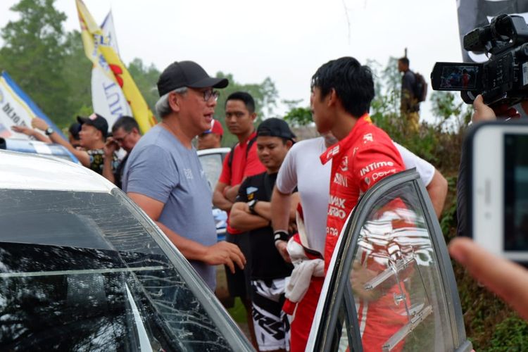 Ricardo Gelael (bertopi) saat mendatangi anaknya, Sean Gelael, usai perlombaan Danau Toba Rally 2019 di kawasan Taman Hutan Industri di kawasan Danau Toba, Sumatra Utara, Sabtu (23/11/2019).
