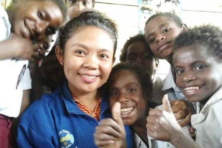 Diana Cristian Da Costa Ati (23) berpose bersama anak-anak muridnya di SD Inpres Kaibusene, Distrik Haju, Kabupaten Mappi, Papua