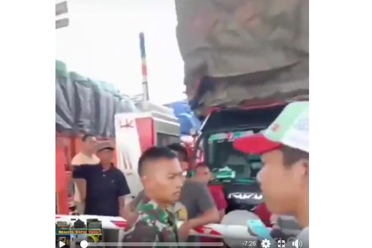 Tangkapan layar dari sebuah unggahan yang memperlihatkan prajurit TNI melarang beberapa sopir truk dengan muatan berlebih melintasi jalan Tol Trans Sumatera.