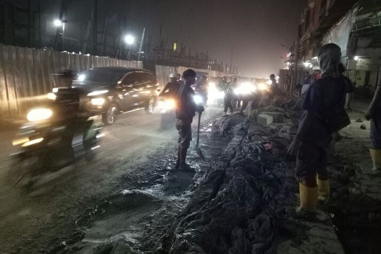 Coran semen proyek pembangunan flyover Simpang Gamplek, Pamulang, Tangerang Selatan, Senin (20/1/2020) sore, rembes ke jalan. Hal tersebut membuat arus lalu lintas mengalami kemacetan panjang.