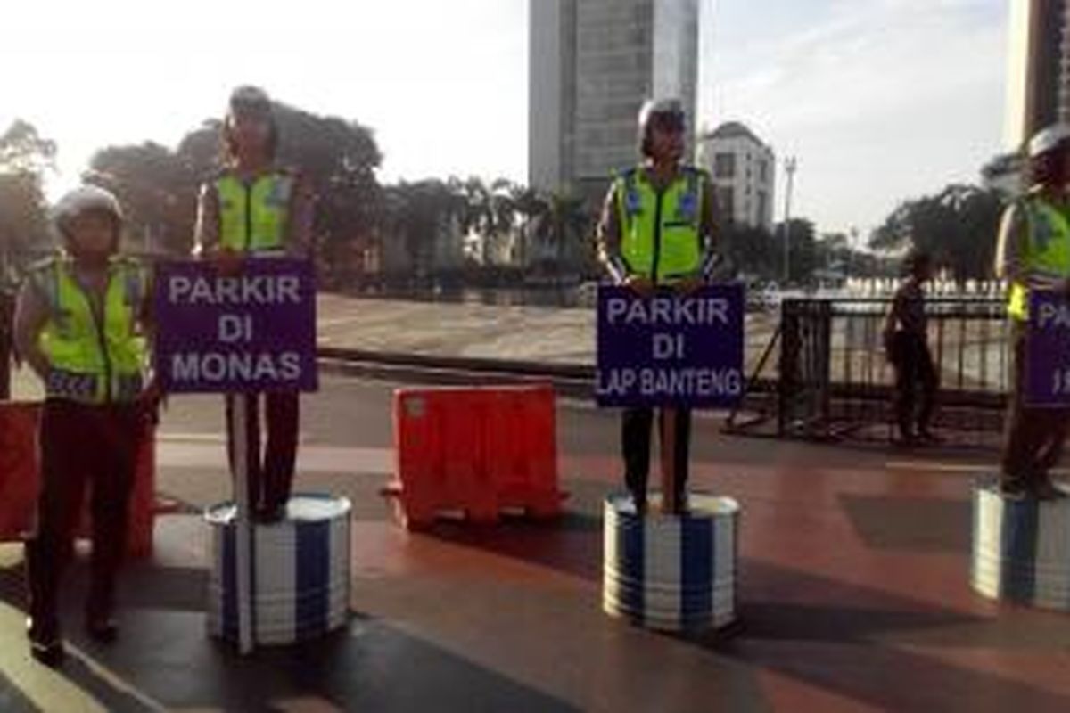 Para polisi wanita membawa papan berisi imbauan parkir untuk buruh di Bundaran HI, Jumat (1/5/2015). 