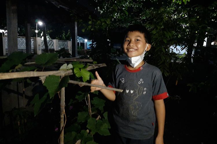 Muhammad Rizqi Maulana saat berada di depan rumahnya di Dusun Jetis, Desa Wedomartani, Kecamatan Ngemplak, Sleman. Anak SD kelas III ini viral setelah dengan sopan menulis surat untuk izin meminta buah jambu mawar kepada pemiliknya.