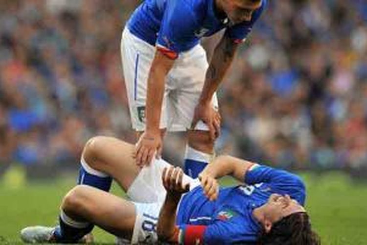 Gelandang Italia, Riccardo Montolivo (terbaring), mengalami cedera saat pertandingan uji coba melawan Irlandia, Sabtu (31/5/2014). Montolivo dibantu gelandang Marco Verratti.