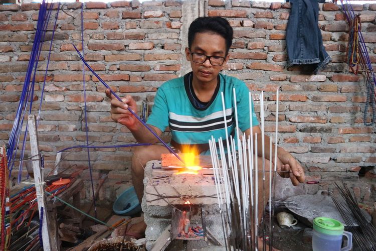 Para pekerja di tempat produksi manik-manik milik Suloso, di Desa Plumbon Gambang, Kecamatan Gudo, Kabupaten Jombang, Jawa Timur, sedang memproses bahan dasar manik-manik menjadi butiran perhiasan.