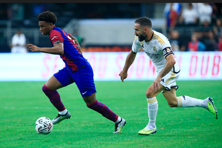 Pemain Barcelona, Alejandro Balde (kiri) dikejar kapten Real Madrid, Dani Carvajal, dalam laga pra-musim bertajuk Soccer Champions Tour di Stadion AT & T, Texas, Amerika Serikat, Minggu (30/7/2023) pagi WIB.