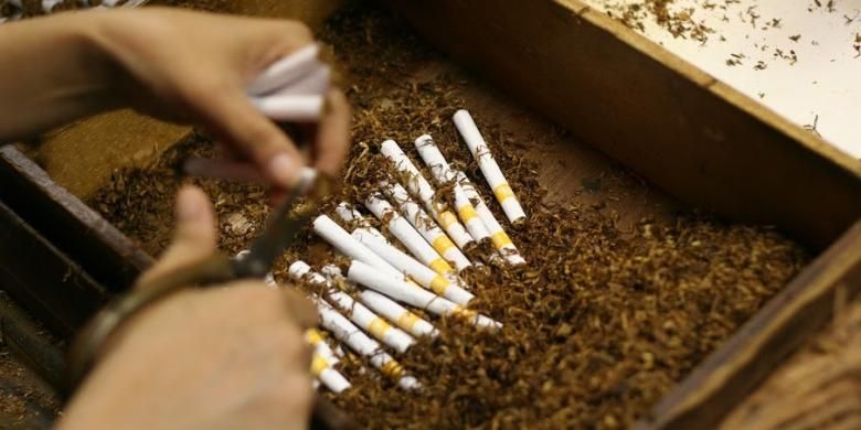 Seorang pekerja sedang memproses pembuatan rokok kretek.