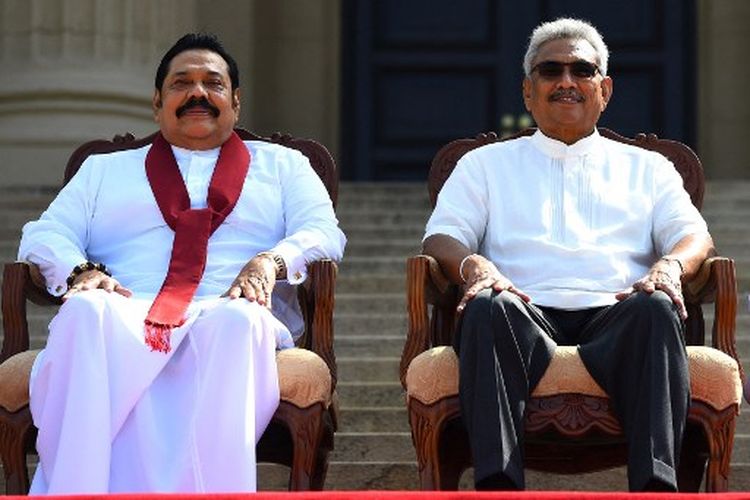 Dalam file foto ini diambil pada 22 November 2019, Presiden baru Sri Lanka Gotabaya Rajapaksa (kanan) dan saudara Perdana Menterinya Mahinda Rajapaksa, berpose untuk foto bersama setelah upacara pelantikan menteri di Kolombo. 