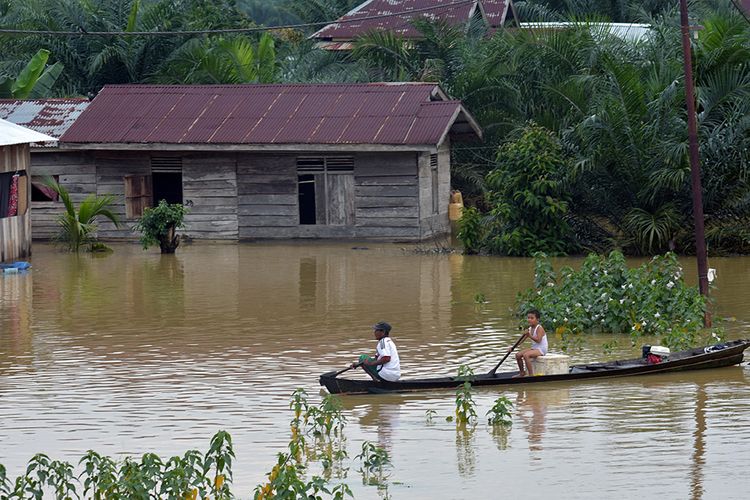 Sejumlah warga terpaksa menggunakan sampan melintasi banjir akibat luapan Sungai Subayang di Kecamatan Gunung Sahilan Kabupaten Kampar, Riau, Rabu (11/12/2019). Berdasarkan data Badan Penanggulangan Bencana Daerah (BPBD) Kampar, tingginya intensitas hujan mengakibatkan air sungai meluap sehingga membanjiri dua desa di Kecamatan Gunung Sahilan, akses jalan desa terputus dan sekitar 276 kepala keluarga terdampak banjir.