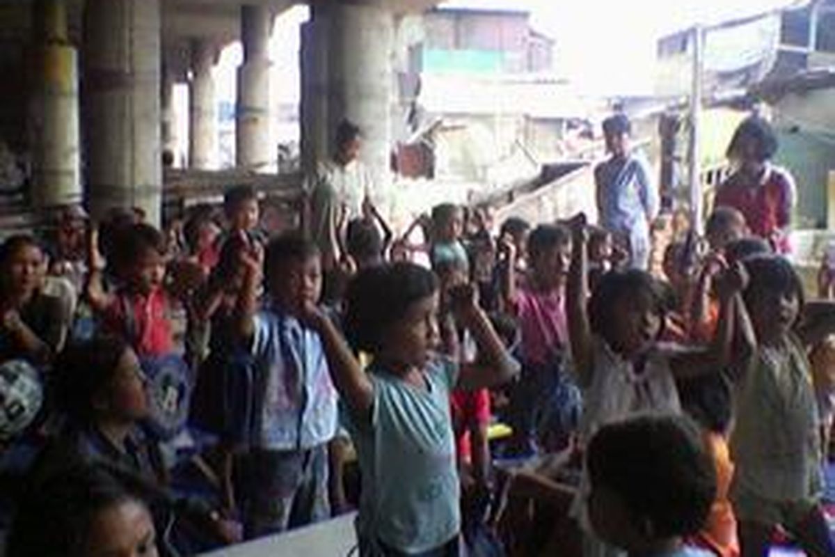 Kegiatan belajar anak-anak di kolong jembatan tol, kawasan Warakas, Jakarta Utara, Rabu (23/7). 