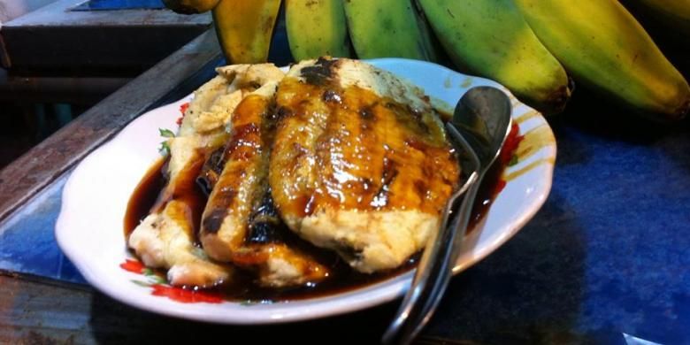 Menyantap seporsi kuliner pisang epe dengan baluran saus gula merah rasa durian di pinggir Anjungan Pantai Losari, Rabu, (11/02/2015).