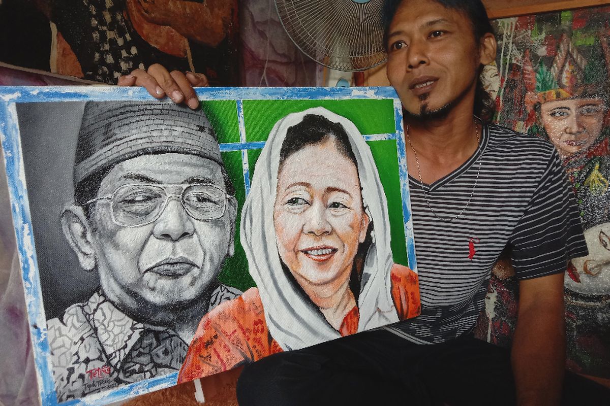 Teguh Tetris, pelukis asal Jombang, Jawa Timur, menunjukkan lukisan yang dibuat dengan memanfaatkan limbah kertas.