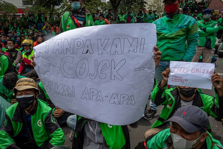 Pengemudi ojek daring yang tergabung dalam Driver Online Bergerak Jawa Tengah berunjuk rasa di depan kompleks Kantor Gubernur Jawa Tengah, Semarang, Jawa Tengah, Senin (7/3/2022). Dalam aksi tersebut mereka mengajukan beberapa tuntutan kepada Pemprov Jateng diantaranya yaitu perlindungan hukum bagi pengemudi daring selaku mitra terkait kesejahteraan, keamanan, dan kenyamanan, pelibatan mitra dalam kebijakan dengan sistem aplikasi, kontrol kuota ojek daring di Jawa Tengah, kenaikan tarif minimal jasa pengantaran penumpang dan barang, serta adanya jaminan asuransi tenaga kerja dari aplikator.