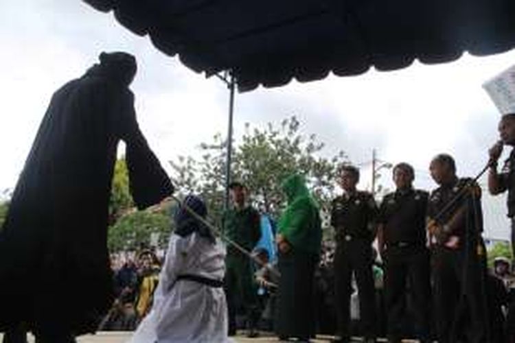 (Prosesi uqubad cambuk terhadap seorang terpidana perempuan disaksikan ratusan masyarakat Aceh Tengah dihalaman Gedung Olah Seni Takengon, Kamis 