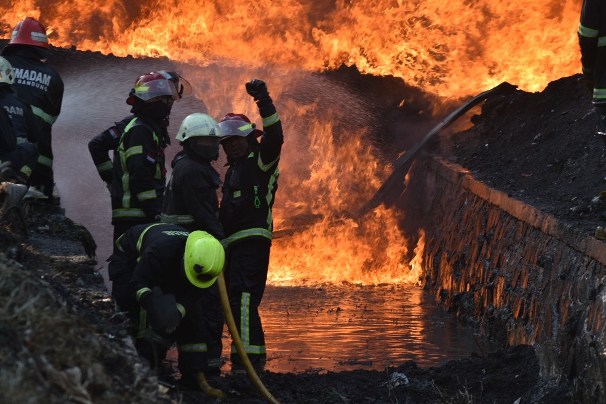 Petugas pemadam kebakaran tengah berupaya memadamkan api di pipa minyak pertamina yang terbakar di Jalur KCIC.