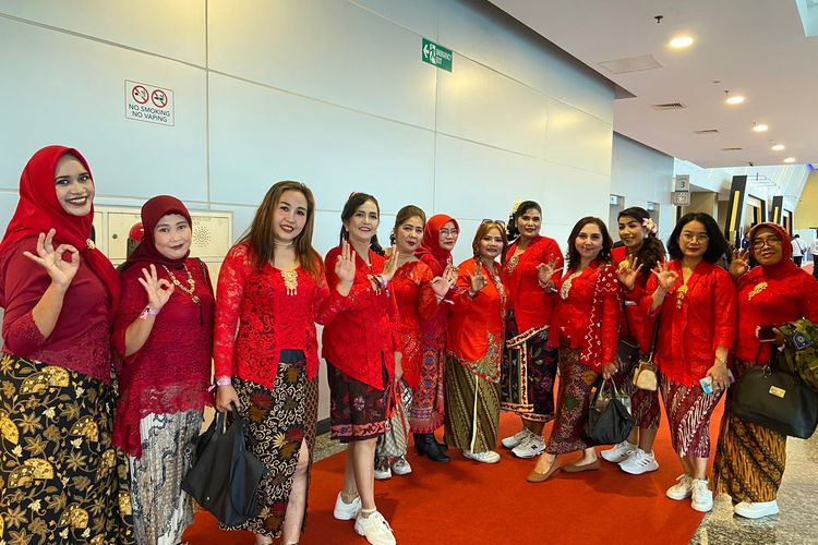 Pendukung calon gubernur dan wakil gubernur Risma-Gus Hans menggunakan kostum tradisional kebaya merah di debat ketiga Pilgub Jatim Senin (18/11/2024).