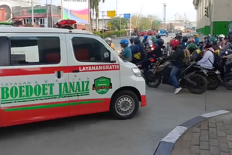 Pengemudi ambulans di Persimpangan Mambo, Jakarta Utara, terpaksa menunggu sementara waktu akibat ulah para pengendara nakal yang melanggar lalu lintas, Senin (13/11/2023). 