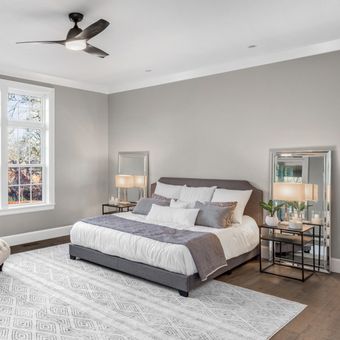 Ilustrasi kamar tidur dengan warna cat abu-abu dan memakai karpet.