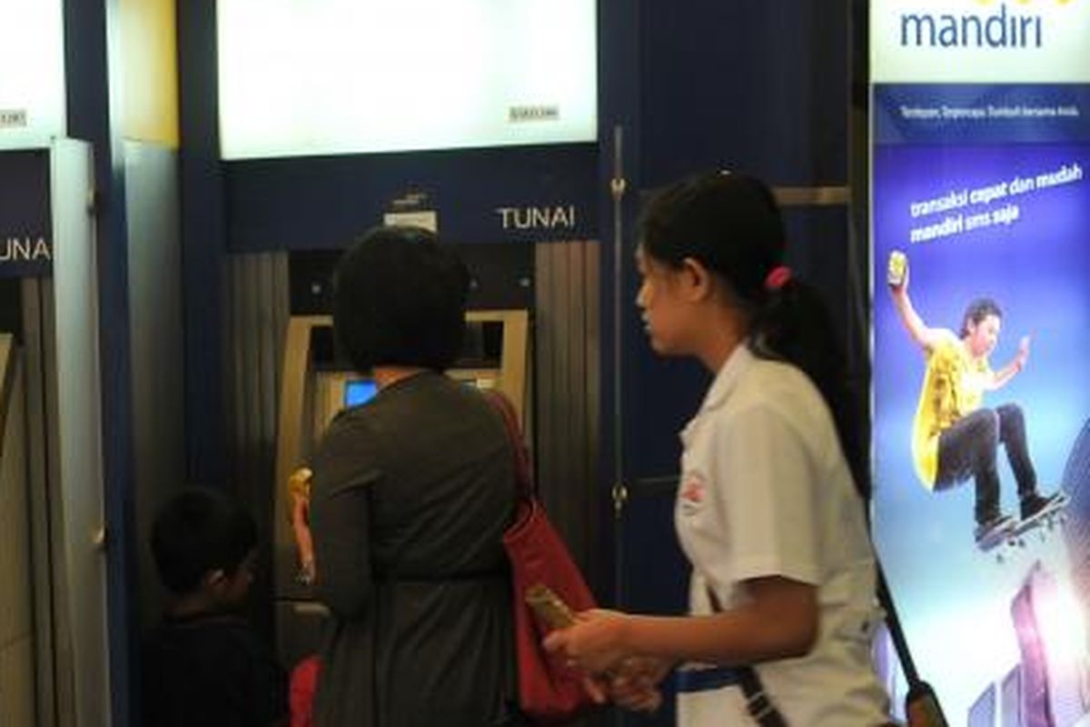 Pengambilan uang tunai di Anjungan Tunai Mandiri (ATM) Bank Mandiri, Jakarta