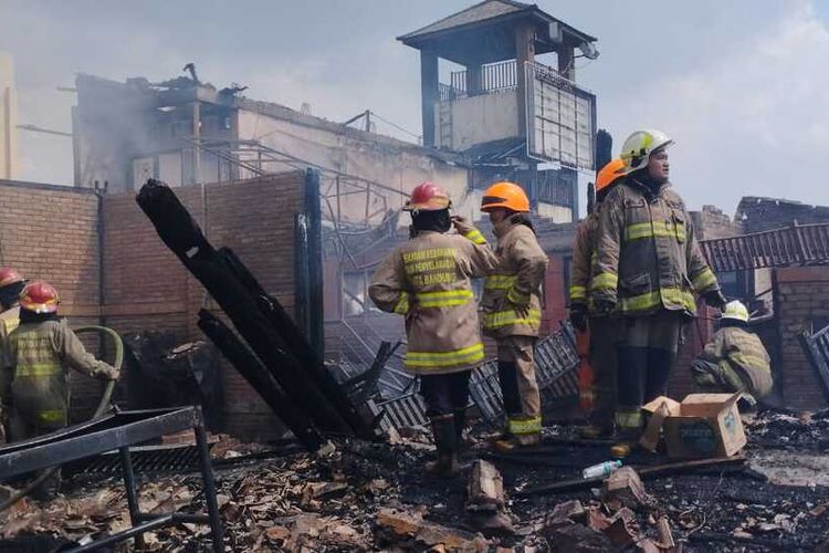 Petugas Diskar PB tengah memadamkan api yang melahap sejumlah bangunan rumah makan di Jalan Soekarno Kota Bandung, Kamis (12/1/2023).