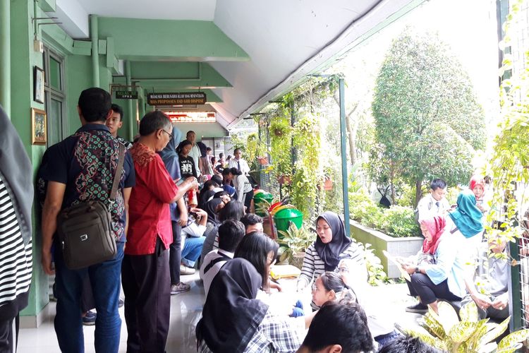 Para orangtua calon murid duduk di lantai SMAN 68, Jakarta Pusat, menunggu pendaftaran PPDB, Senin (24/6/2019)