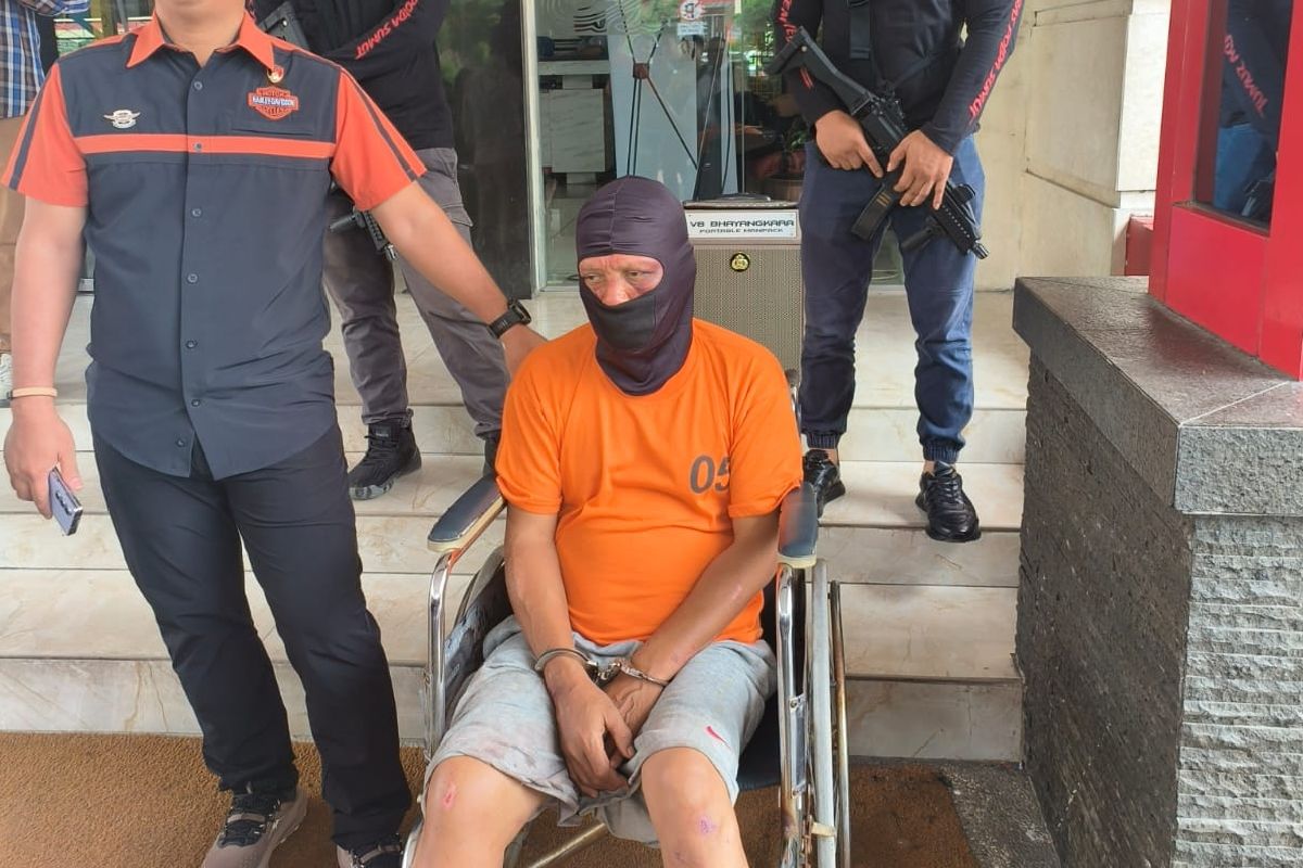 Polisi saat menangkap Ilham Batubara (58), perampok yang dikenal menggunakan parang dan pistol saat menjalankan aksinya di Kabupaten Sergai, Kamis (10/4/2025)   