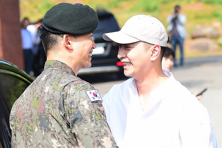 Aktor dan penyanyi K-pop Taecyeon disambut rekannya dari 2PM Chansung (berbaju dan bertopi putih) setelah ia menyelesaikan wajib militer, Kamis (16/5/2019).