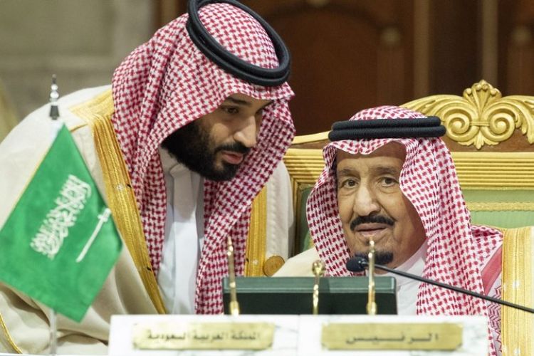 Putra Mahkota Saudi Mohammed bin Salman (kiri) berbicara dengan Raja Arab Saudi Salman bin Abdulaziz di Istana Diriya di Riyadh selama KTT Dewan Kerja Sama Teluk (GCC), Minggu (9/12/2018). (AFP/SPA/Bandar Al-Jaloud)
