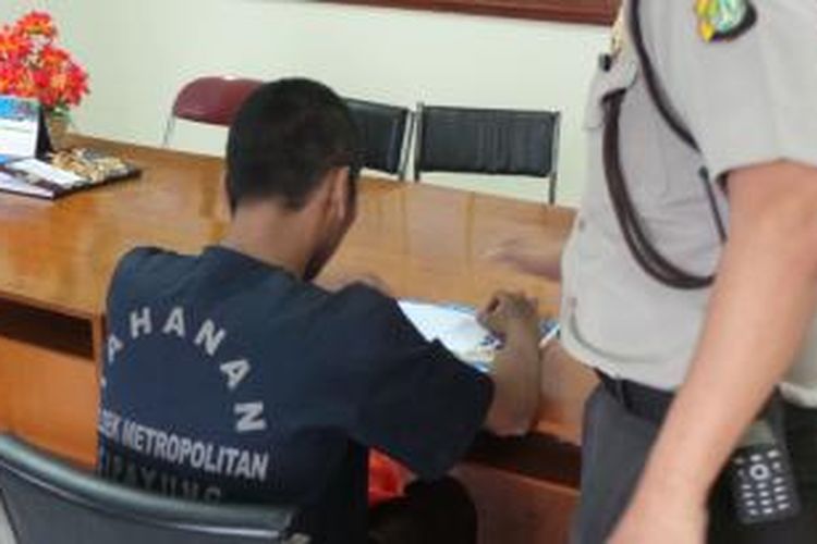 Ydk (19) pelajar yang tertangkap seminggu sebelum UN ini mesti mengerjakan soal ujian di kantor Polsek Cipayung, Jakarta Timur. Senin (14/4/2014).