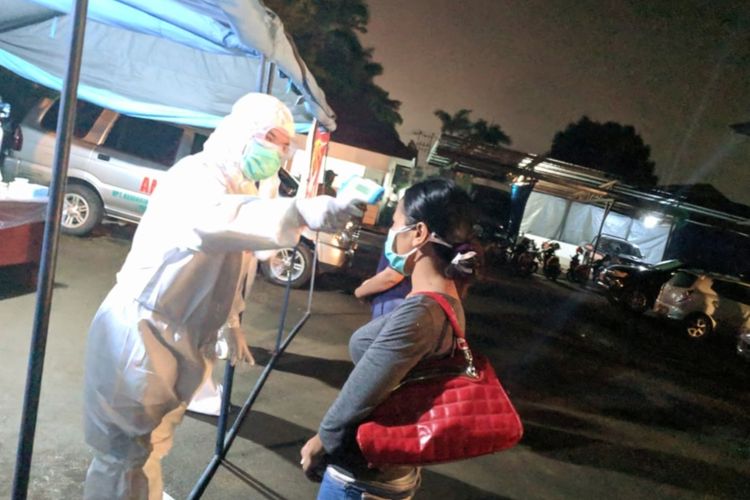 Seorang pekerja migran Indonesia diperiksa kesehatannya udai tiba di Kantor Dinas Sosial Kalimantan Barat, Jumat (15/5/2020) malam.