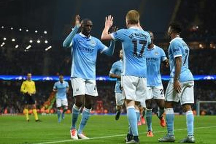 Yaya Toure menyelamati Kevin De Bruyne yang mencetak gol kemenangan Manchester City ke gawang Sevilla, Rabu (21/10/2015). 