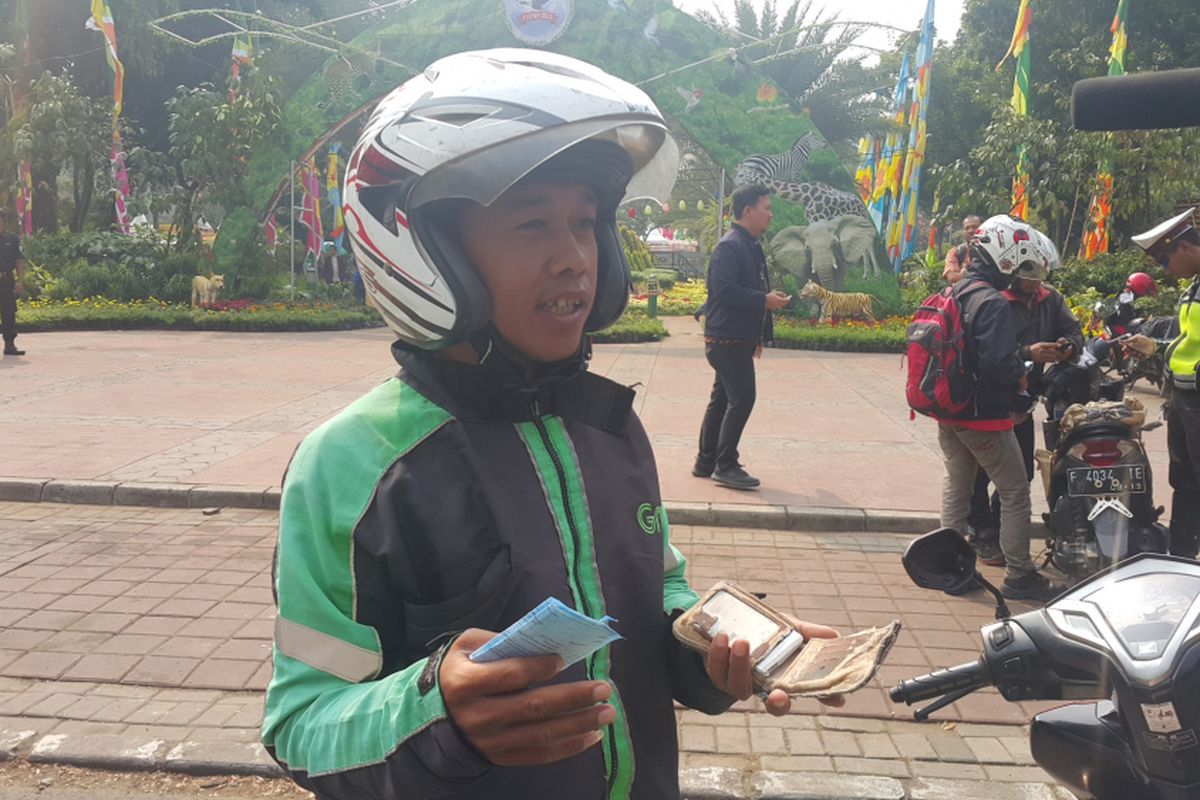Pengemudi ojek online, Salman (26), ditinggalkan penumpangnya karena terjaring razia. Salman ditilang polisi di Jalan Lapangan Banteng Selatan, Jakarta Pusat, Jumat (11/8/2017), karena menunggak pajak kendaraan bermotornya.