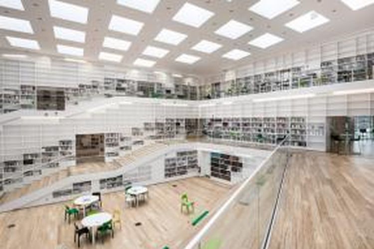 Tangga dan rak buku membungkus atrium berlantai tiga gedung perpustakaan universitas ini. Sebuah konsep yang dirancang oleh Adept, studio arsitektur berbasis di Denmark untuk menggambarkan apa yang mereka sebut dengan 