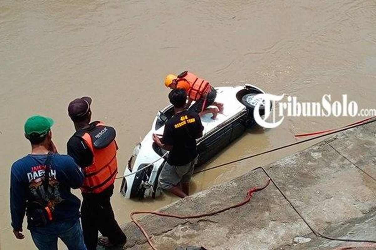 Petugas penyelamat berusaha mengangkat Honda Brio yang terjun ke Kali Anyar di Kelurahan/Kecamatan Jebres, Solo, Rabu (15/3/2023). Mobil yang dikemudikan Sri Lestari tersebut tercebur karena sopirnya keliru menginjak pedal gas daripada rem.