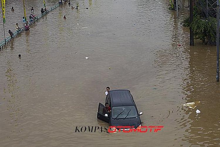 Luapan Kali Ciliwung memutus jalur kendaraan di Jalan KH Abdullah Syafiie, Tebet, Jakarta Selatan, Senin (13/1/2014)