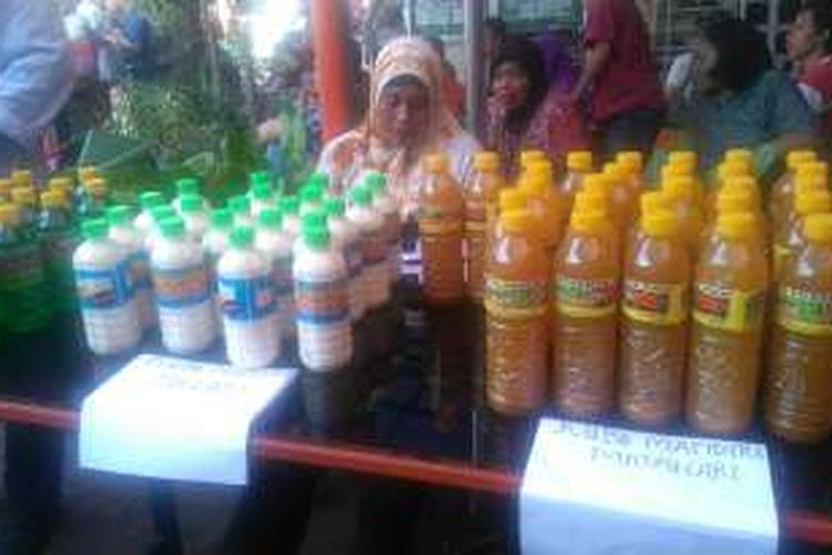 Supartun (42) menjajakan produjsi dagang susu keselai dan kunyit asam di acaara pencairan dana Prigram Keluarga Harapan (PKH) yang diselenggarakan di Kantor Pos Surabaya Selatan, Kota Surabaya, Jawa Timur, Sabtu (25/6/2016).