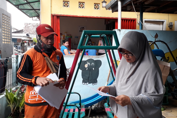 Petugas PPSU memberikan revisi surat edaran Lurah Cilandak Barat Agus Gunawan tentang pengumpulan zakat untuk RT kepada Ketua RT 008 RW 010, Sri Mulyantini, Minggu (3/6/2018).