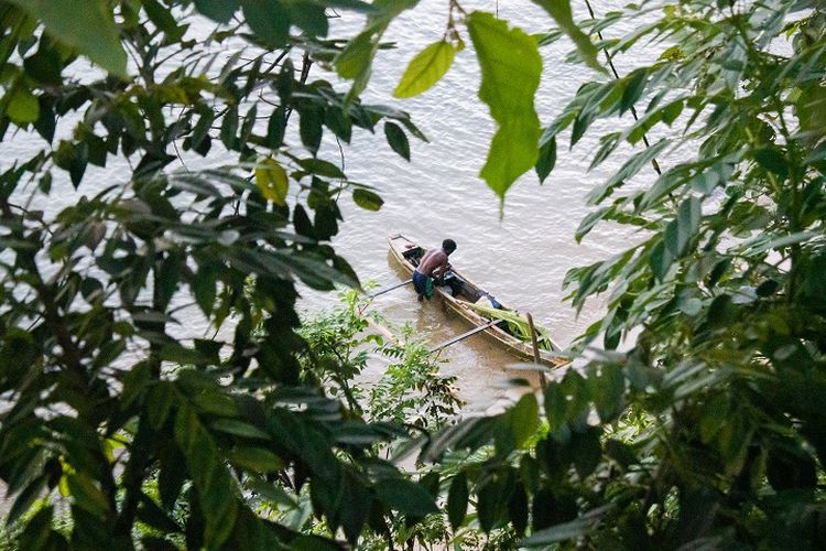 Pemandangan seorang warga lokal yang tengah membenahi kapal dari tepi pantai yang dilihat dari area tebing di Kasuari Valley Beach Resort di Kota Sorong, Papua Barat, Senin (25/10/2021).