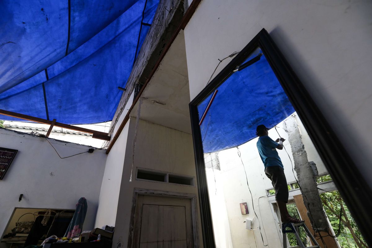 Warga memasang tenda untuk menutup atap rumah warga di Jalan Kebon Kopi RT 001 RW 007, Pengasinan, Sawangan, Depok, rusak akibat diterpa angin puting beliung pada Senin (10/10/2022). Kerusakan akibat puting beliung Minggu (9/10/2022) didominasi di bagian atap.
