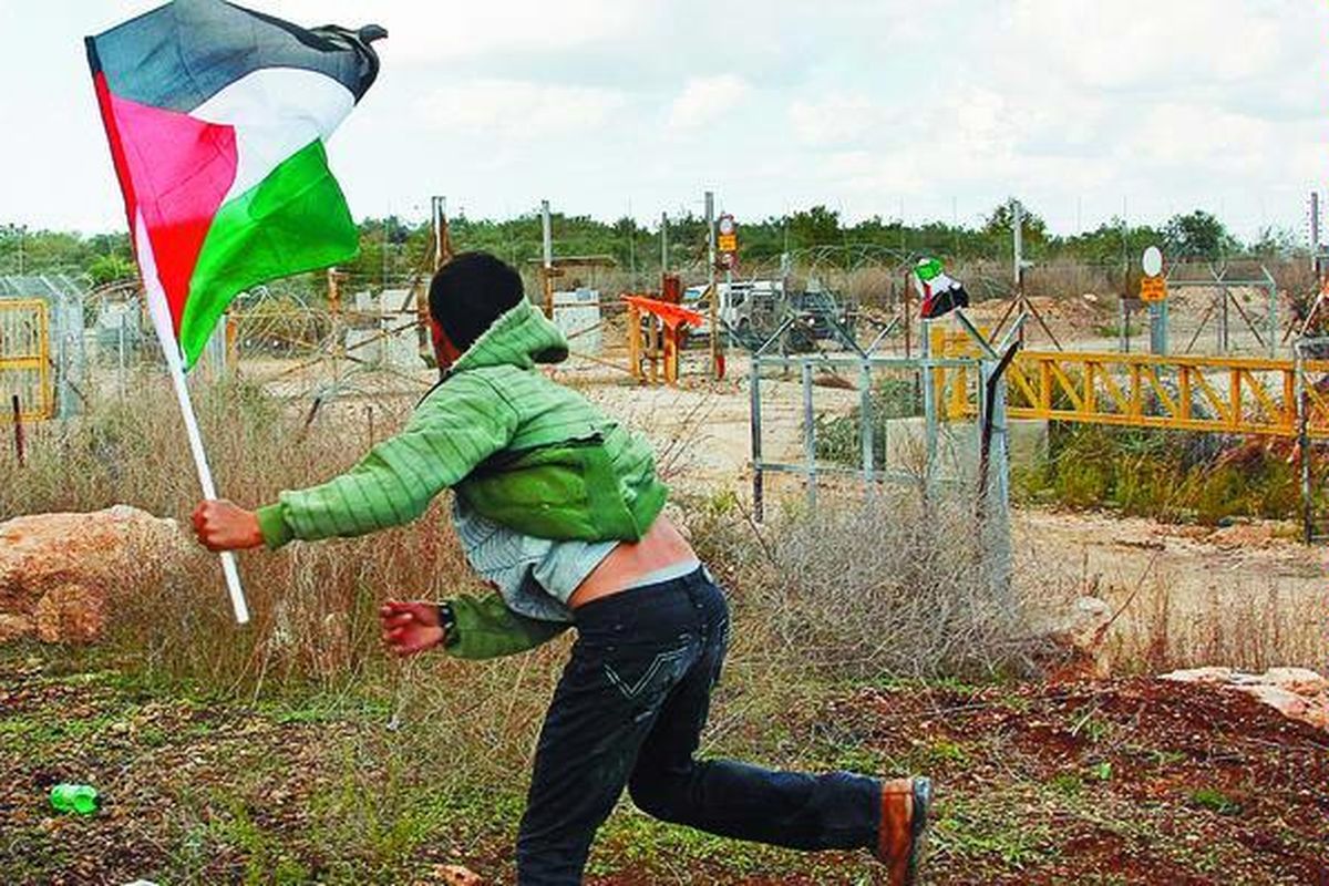 Ilustrasi: Pemuda Palestina melemparkan batu ke arah pasukan keamanan Israel di pagar pemisah kontroversial di Desa Deir Al-Ghson dekat Tulkarem, Tepi Barat.