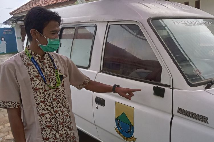 Seorang pegawai Puskesmas Cugenang, Cianjur memerlihatkan kondisi ambulan yang dirusak kawanan monyet.