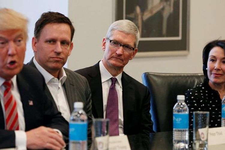 Presiden terpilih Amerika Serikat Donald Trump (paling kiri) berbicara sambil disaksikan oleh pendiri PayPal Peter Thiel (kedua dari kiri), CEO Oracle Safta Catz (paling kanan), dan CEO Apple Tim Cook dalam pertemuan dengan para petinggi perusahaan teknologi yang digelar di Trump Tower, New York, Rabu (14/12/2016) minggu lalu. 